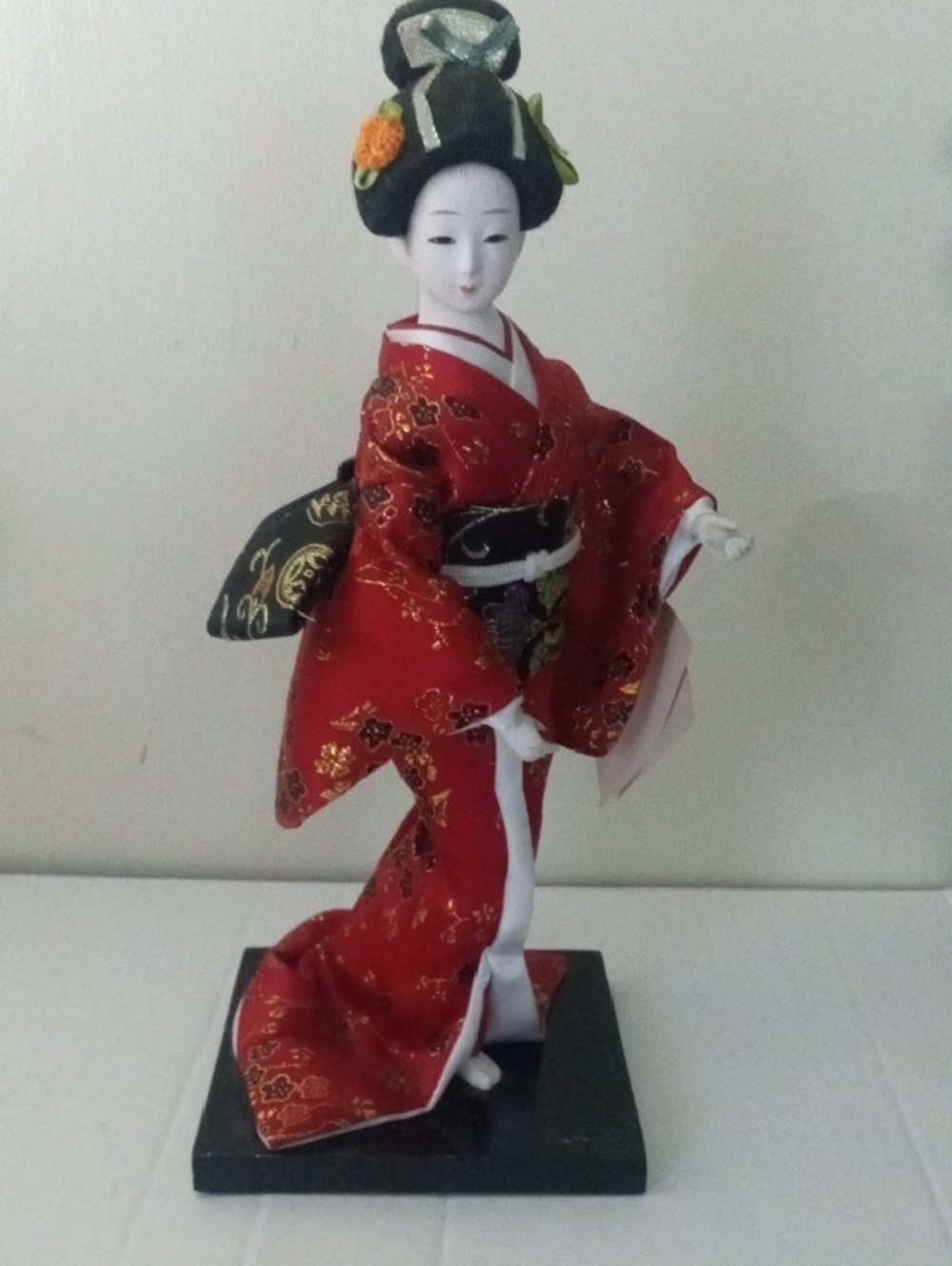 Japanese Geisha Doll in Red Kimono with Pretty Hair Pins Posing on Black Stand